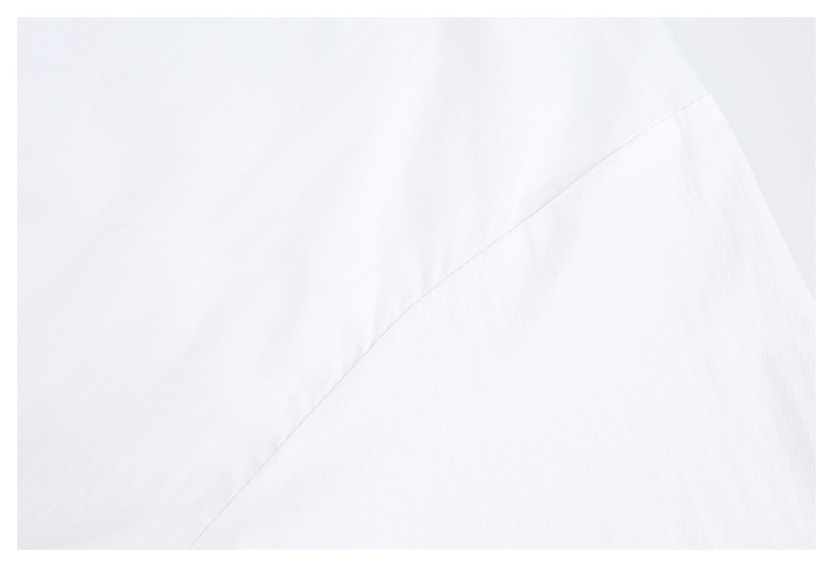 Close-up of white garment fabric with a diagonal seam.