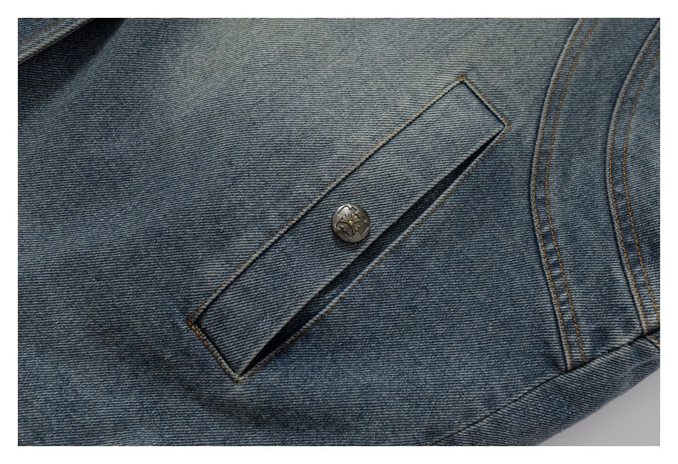 Close-up of a buttoned flap pocket on a blue denim jacket.