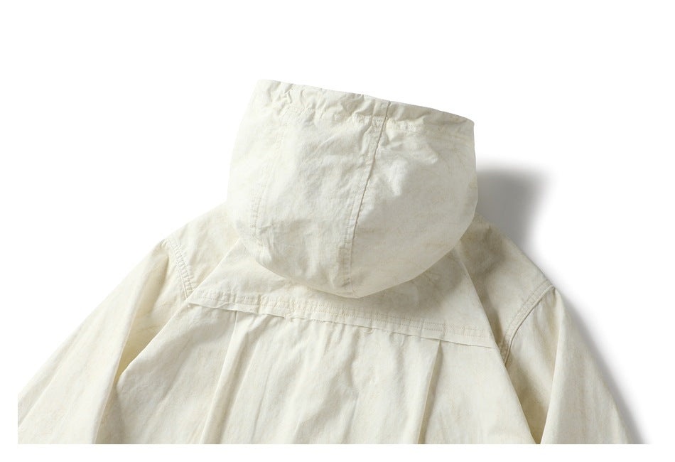 Close-up of the back of an off-white hooded jacket, showing the hood, shoulder seams, and pleated back panel.