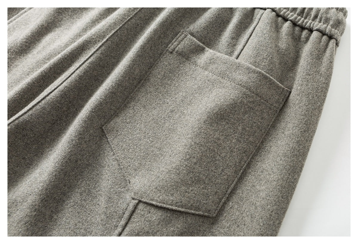 Close-up of a large patch pocket on light gray pants, with part of the elastic waistband visible.