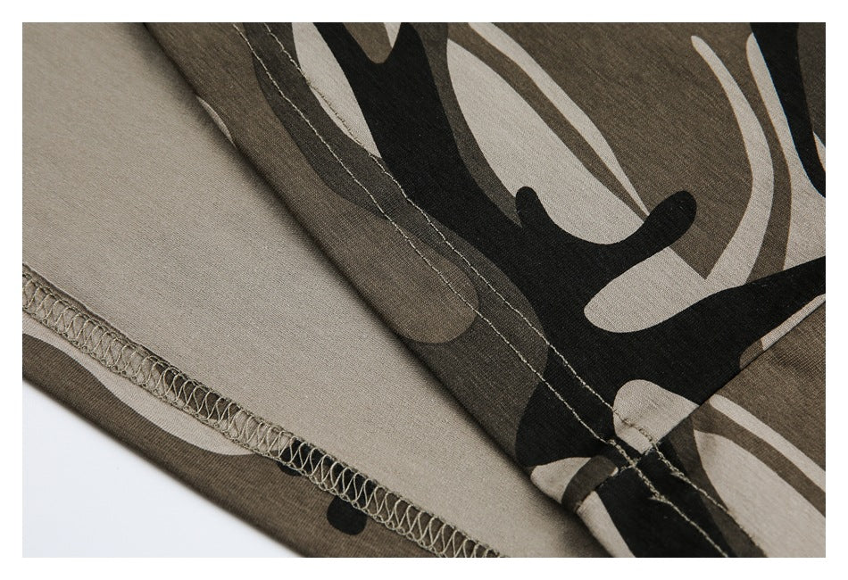 Inside view of camouflage garment fabric showing an overlocked seam and stitching.
