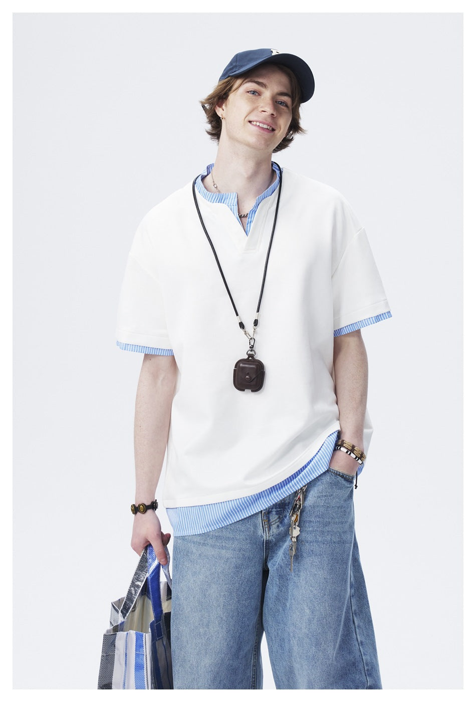 Model wearing an oversized white short-sleeve top with blue striped collar, sleeve, and hem accents.