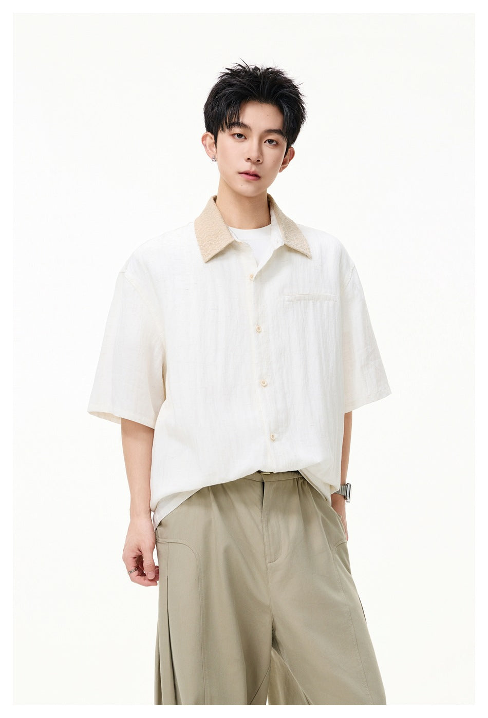Model wearing an oversized ivory short-sleeve shirt with a beige textured collar and chest pocket, paired with khaki