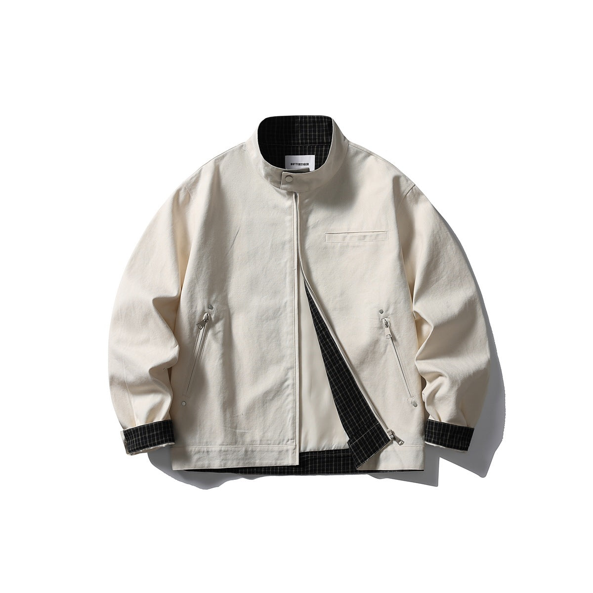 Front view of an ivory stand-collar jacket with a partly open zipper, chest welt pocket, and angled zip pockets.