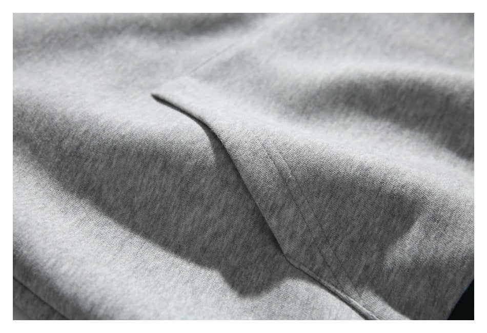Close-up of gray knit garment fabric with a curved stitched seam.