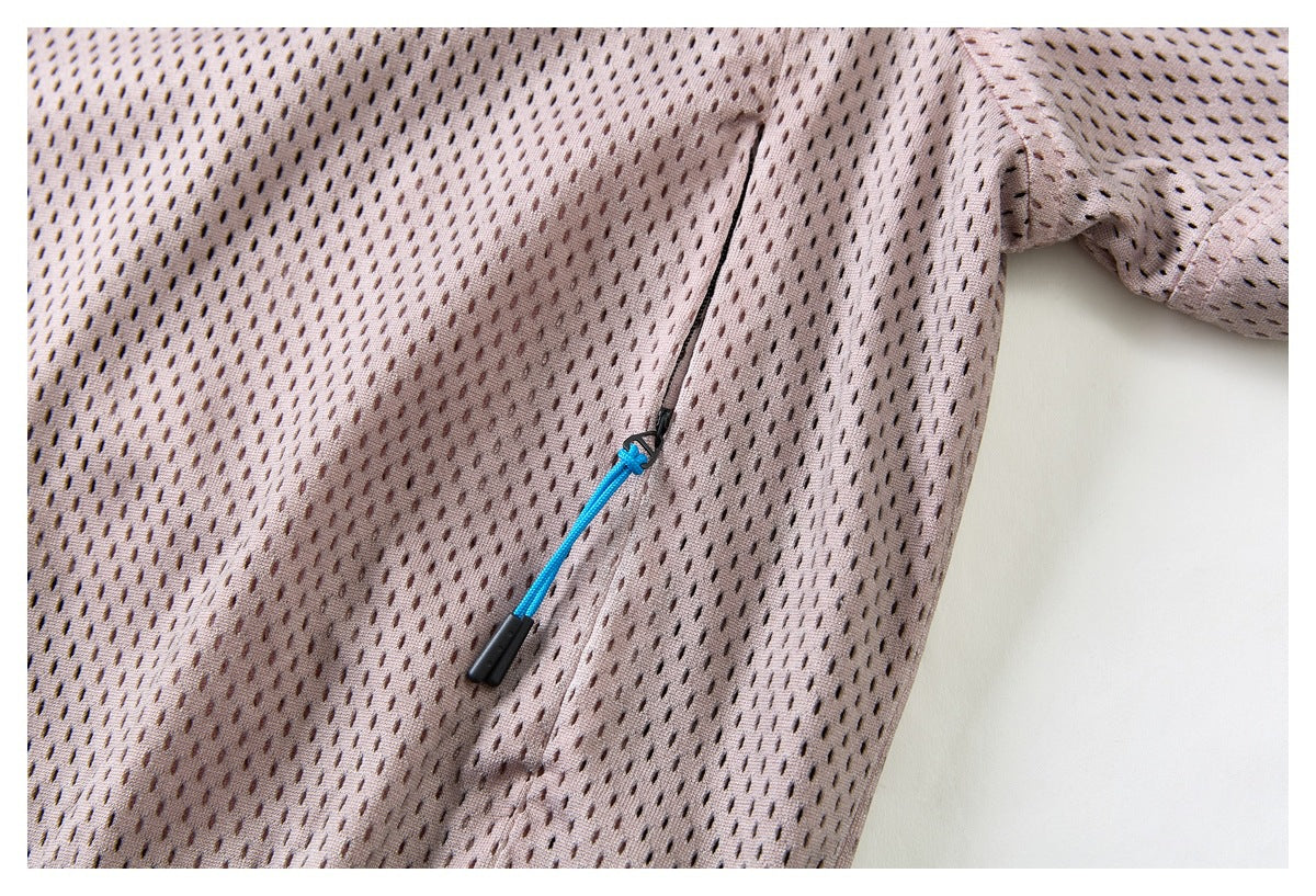 Close-up of a zipper with a blue cord pull on pale mauve perforated fabric.