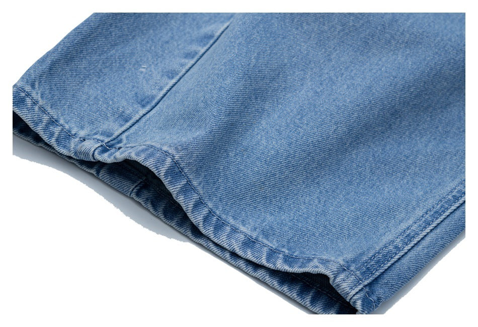 Close-up of the hem and stitched edge of a light blue denim pant leg.