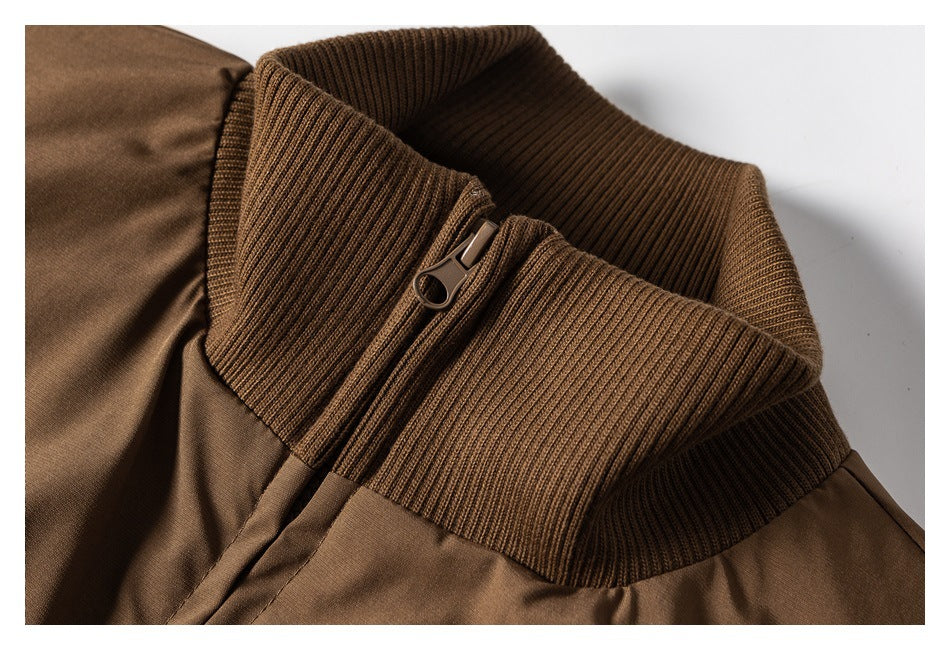 Close-up of a brown jacket's ribbed stand collar and zipper pull.