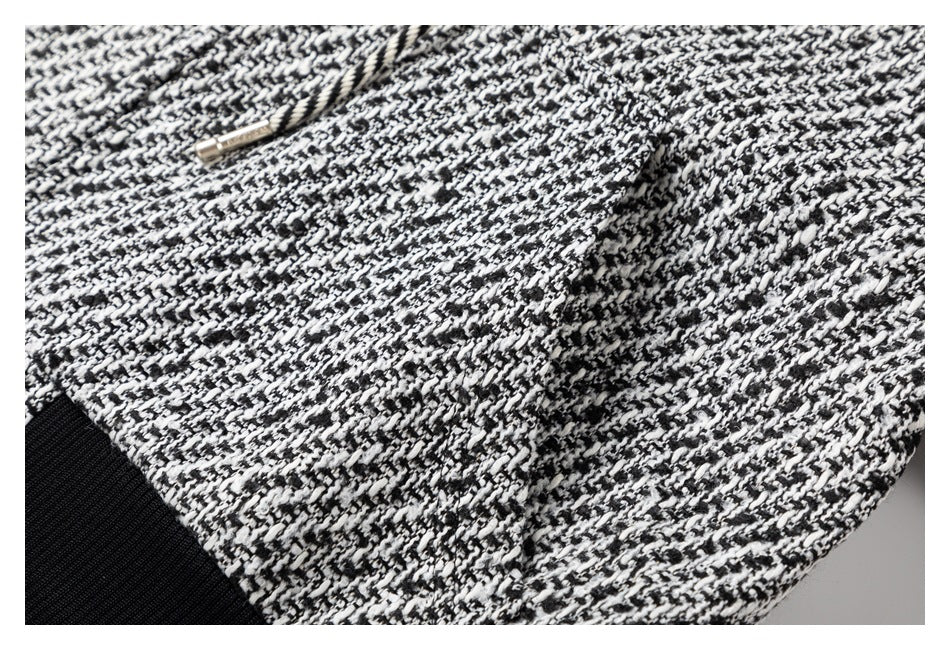 Close-up of the garment's black-and-white patterned fabric and a front pocket.