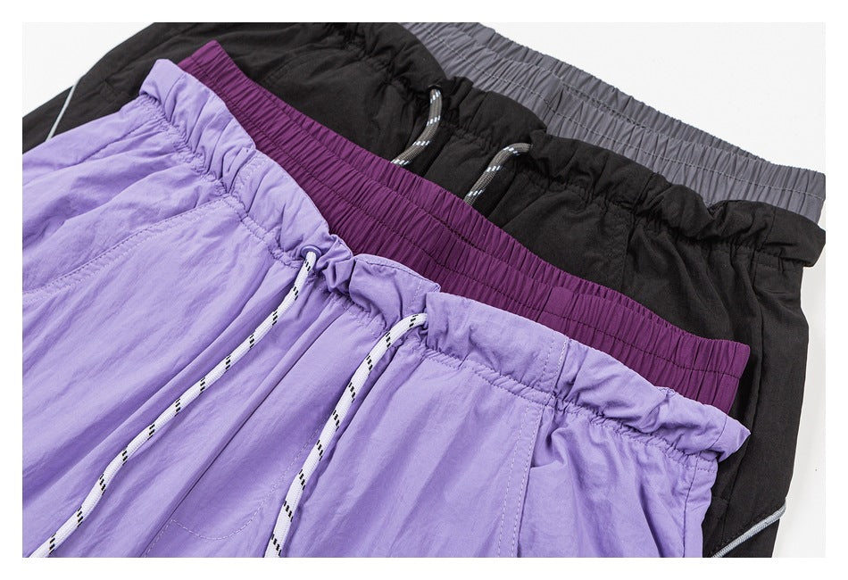 Close-up of lavender, black, and plum wide-leg pants showing elastic waistbands and drawstrings.