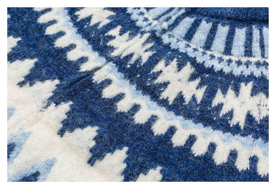 Close-up of the blue-and-white geometric knit pattern across a sweater yoke.