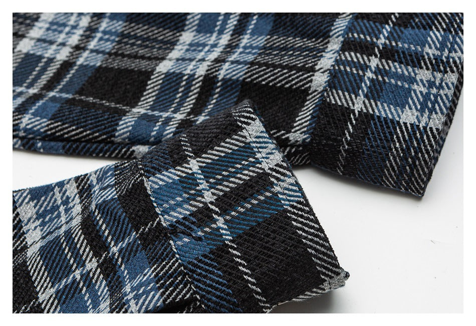 Close-up of blue, black, and gray plaid fabric folded to show its pattern and texture.
