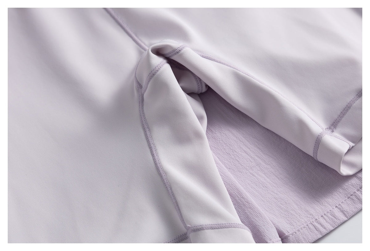 Close-up of pale lavender garment fabric showing stitched seams and a folded edge.
