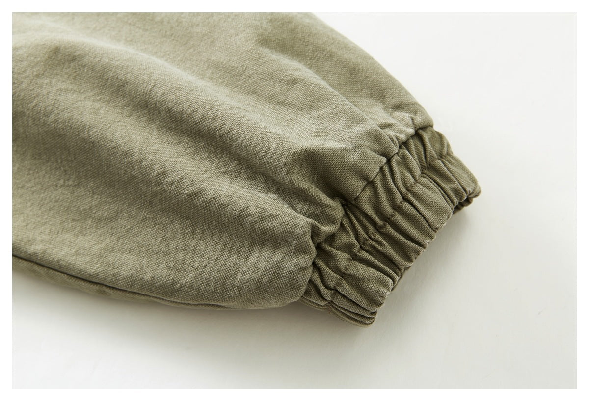 Close-up of the gathered elastic cuff on an olive khaki jacket sleeve.