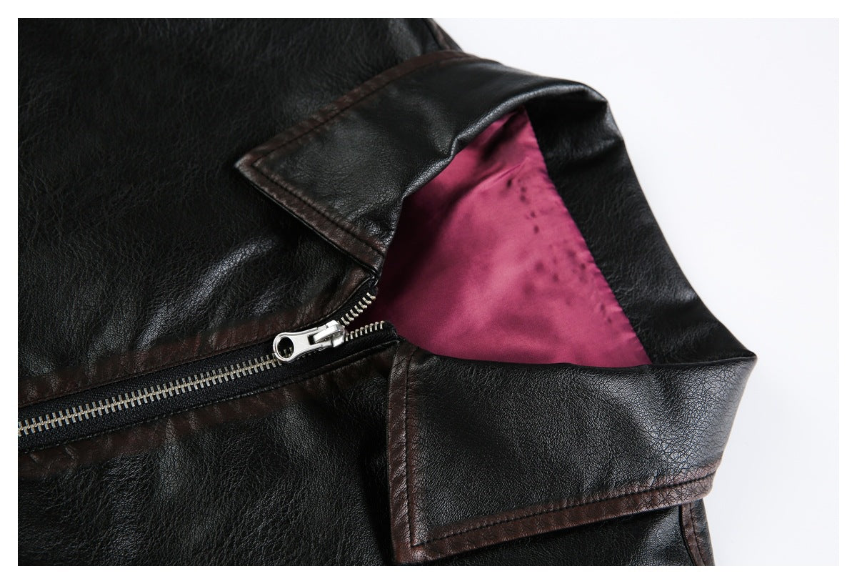 Close-up of a black jacket's collar, silver zipper, and magenta lining.