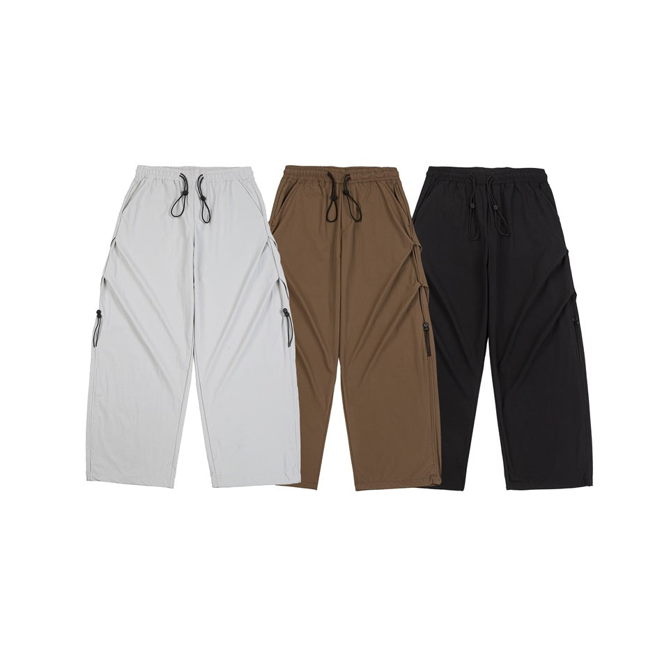 Three pairs of wide-leg trousers shown from the front in light gray, taupe, and black.