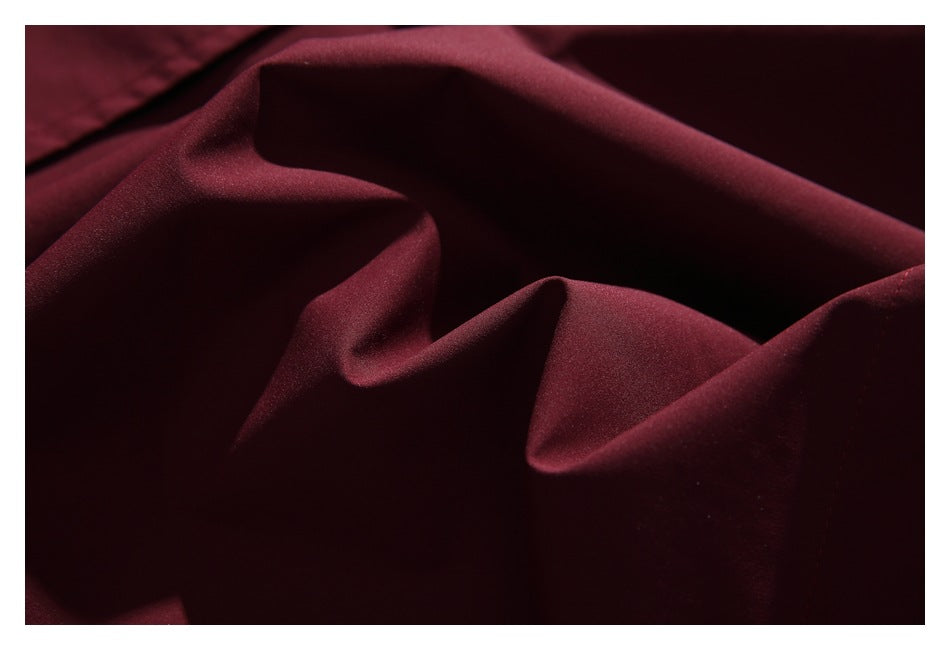 Close-up of deep burgundy fabric arranged in soft folds.