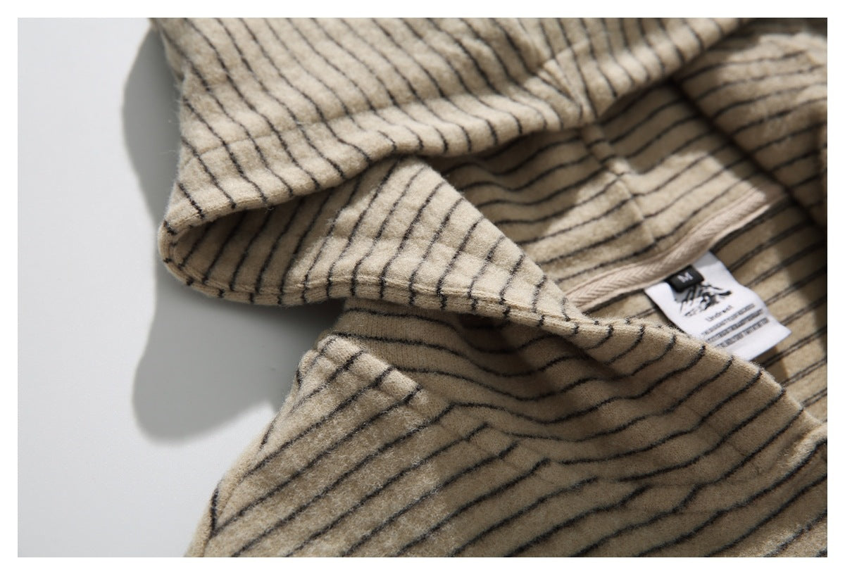 Close-up of the striped hood opening and neck label on a beige garment.