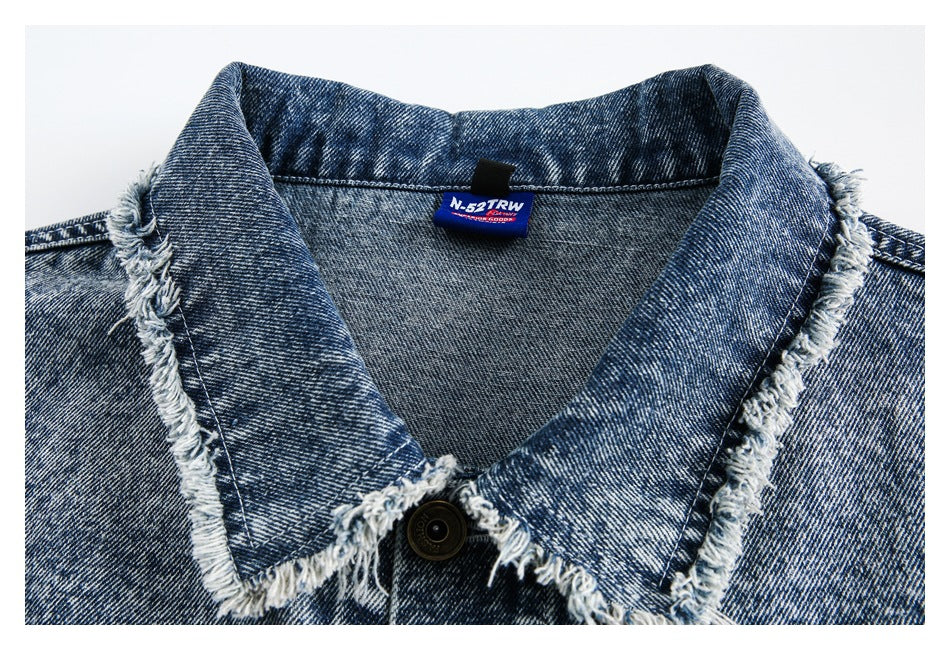 Close-up of the jacket's acid-wash denim collar, frayed edges, button and sewn-in neck label.