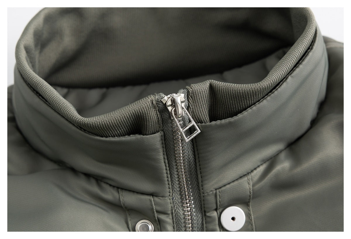 Tight view of the olive-gray jacket collar and silver zipper pull with snap buttons below.