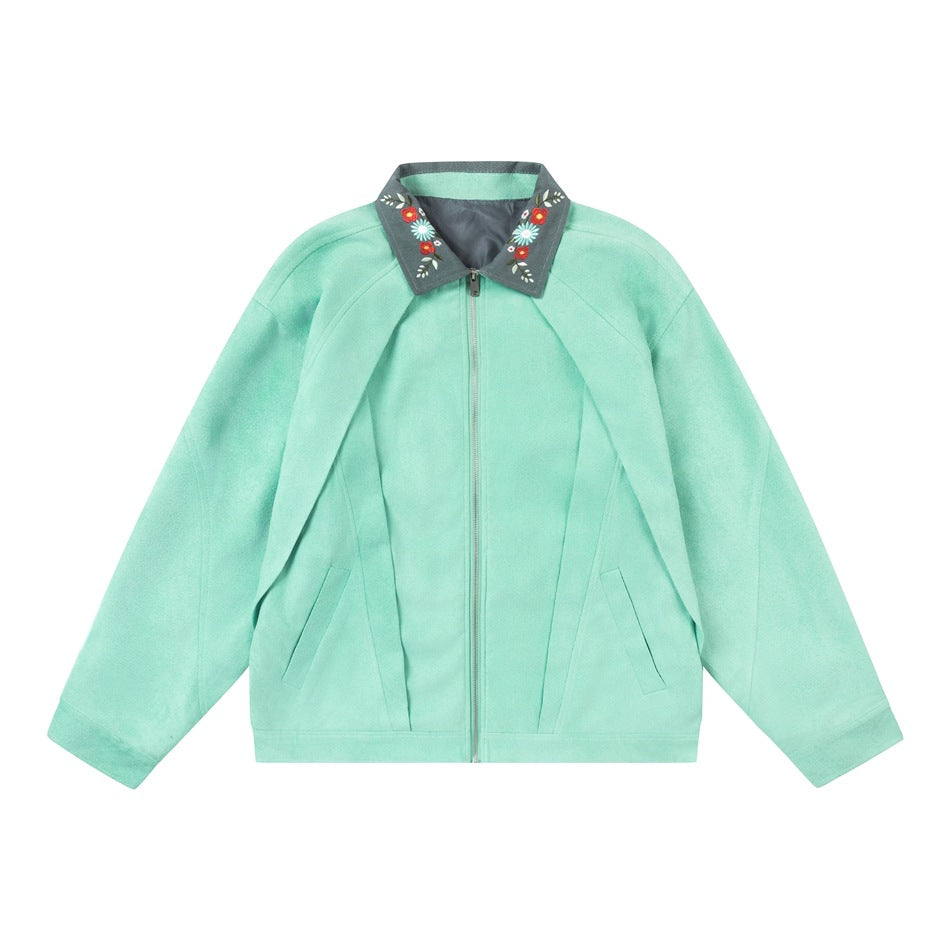 Light green zip-front jacket with gray floral-embroidered collar and pleated front panels, flat lay on white