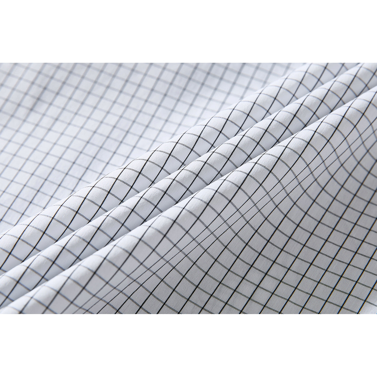 Close-up of white shirt fabric with a fine black windowpane check, shown in soft folds.