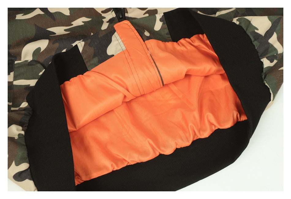 Close-up of the jacket’s bright orange inner lining framed by black ribbed trim and camouflage fabric.