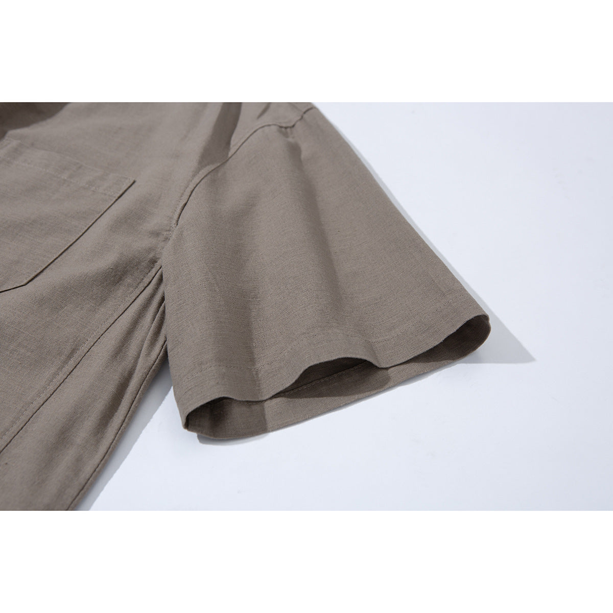 Close-up of the taupe shirt's short sleeve, cuff, and side seam.