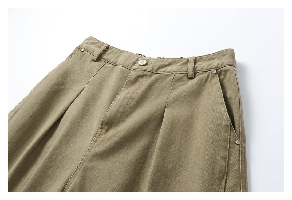Front view of tan pants laid flat, showing pleats, belt loops and buttons at the waist and side.
