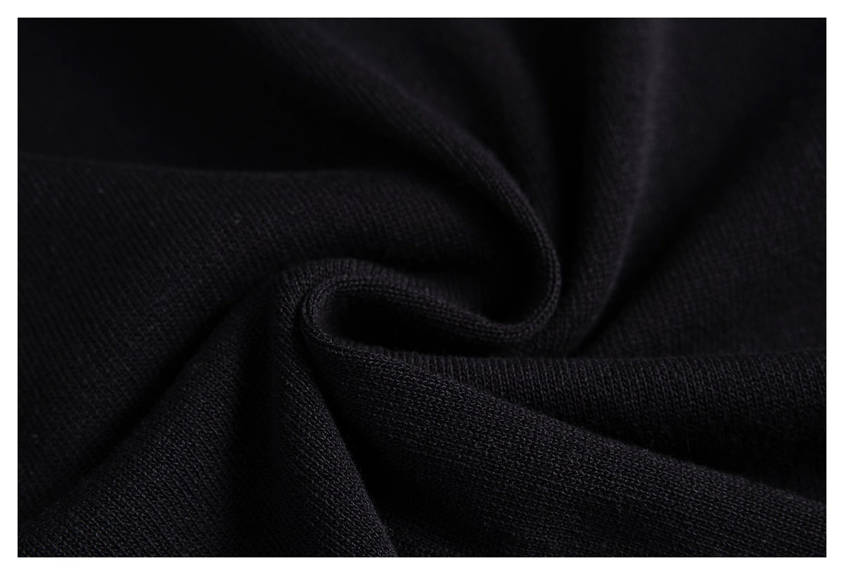 Close-up of black knit fabric gathered into soft folds, showing its texture.
