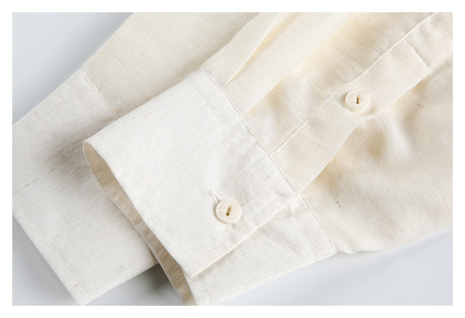 Close-up of an ivory shirt cuff with two matching buttons and stitched placket details.