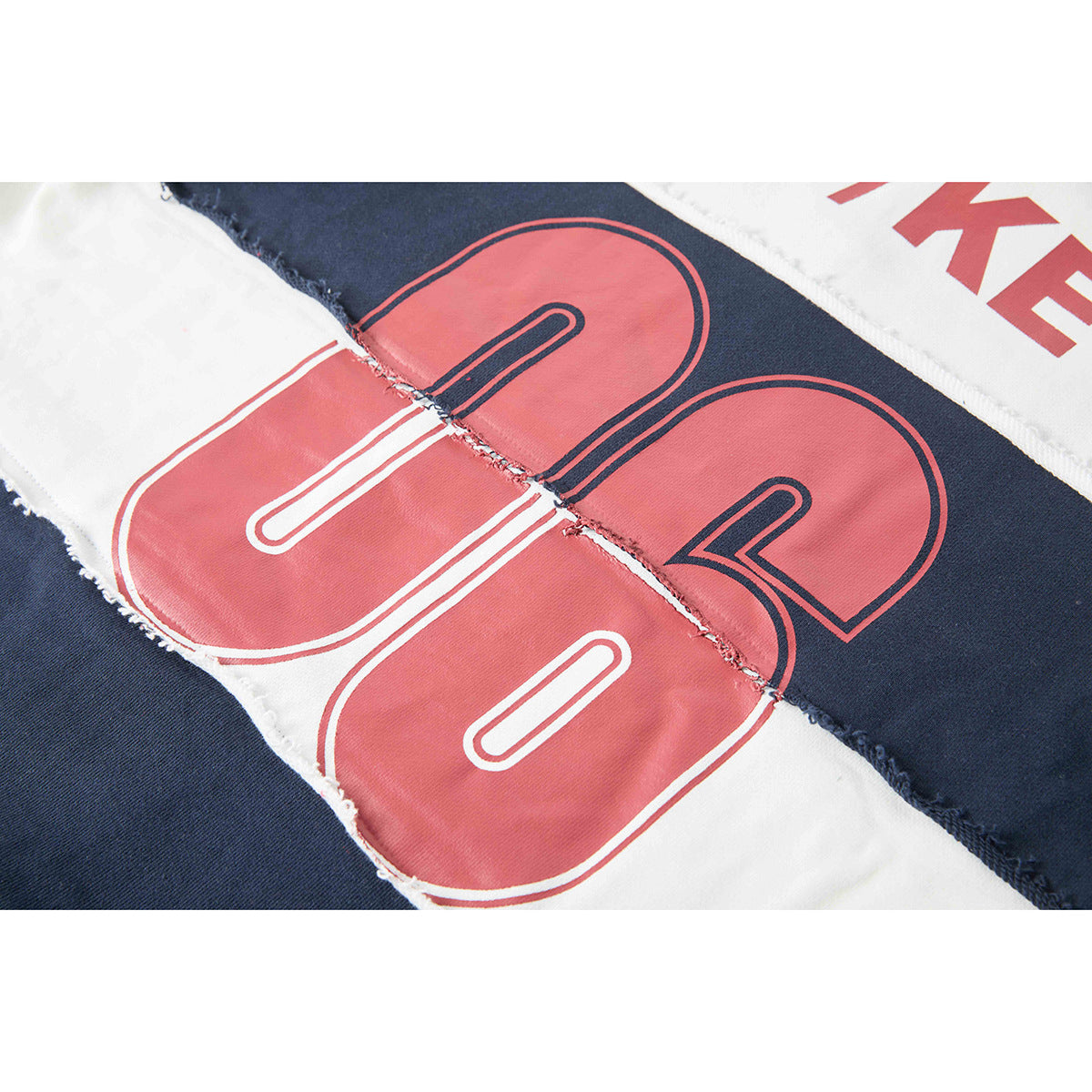 Close-up of large red outlined numerals printed across navy and white stripes on a shirt.
