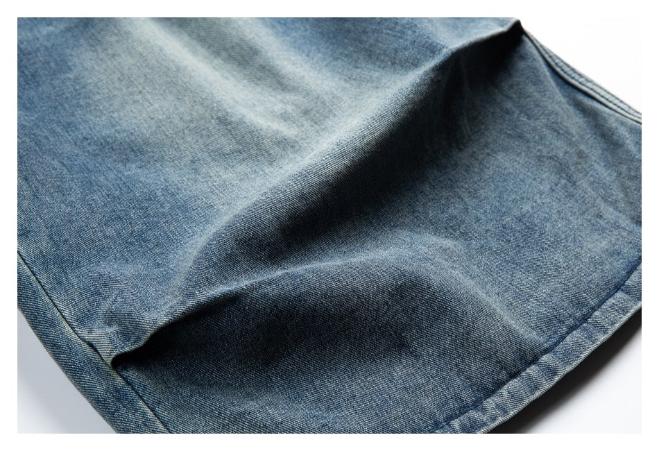 Close-up of blue denim shorts showing the fabric texture, folds and stitched hem.