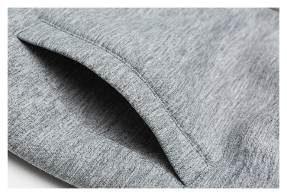 Close-up of a curved pocket opening and stitching on heather gray knit fabric.
