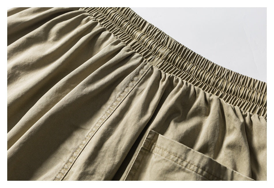 Close-up of khaki shorts showing the elastic waistband and a large patch pocket.