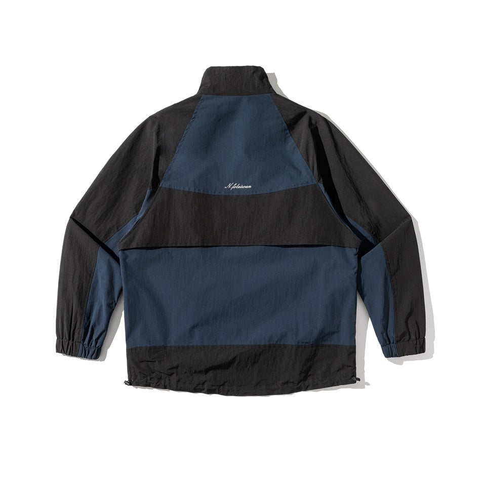 Back view of a navy and black color-block jacket with a high collar, elastic cuffs, and adjustable hem.
