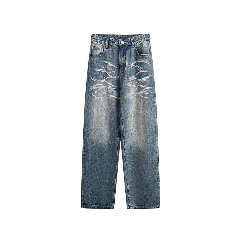 Washed blue straight-leg jeans flat lay with faded wash and light branch-like distressing on the front