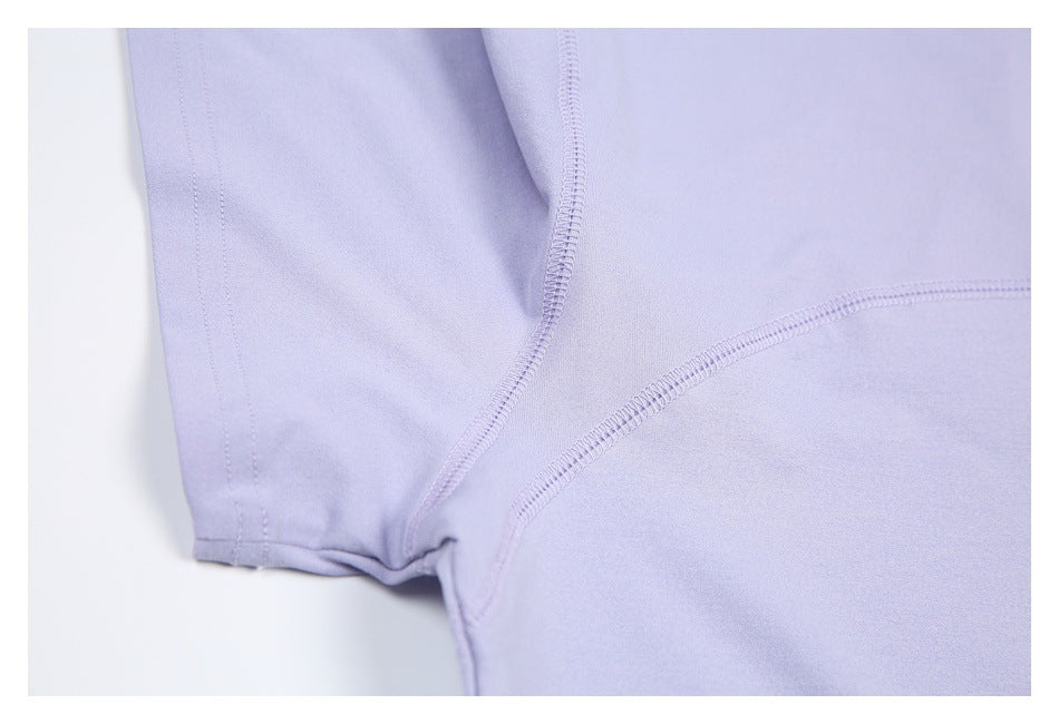 Close-up of pale lavender garment construction showing intersecting overlocked seams and a stitched edge.