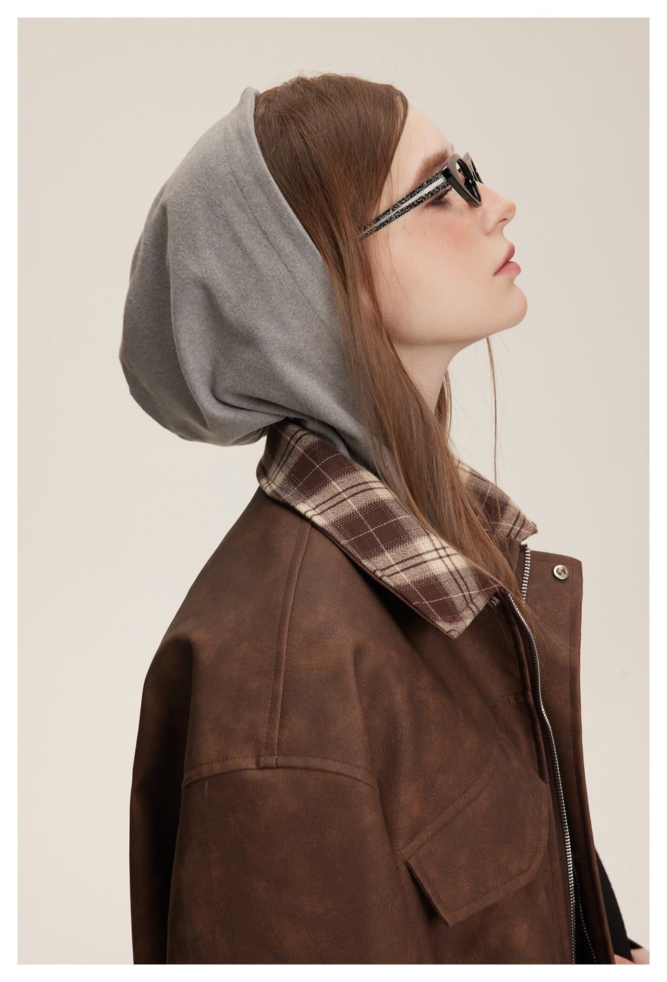 Side close-up of the jacket's brown plaid collar, gray hood, shoulder seam and zip-front fastening.
