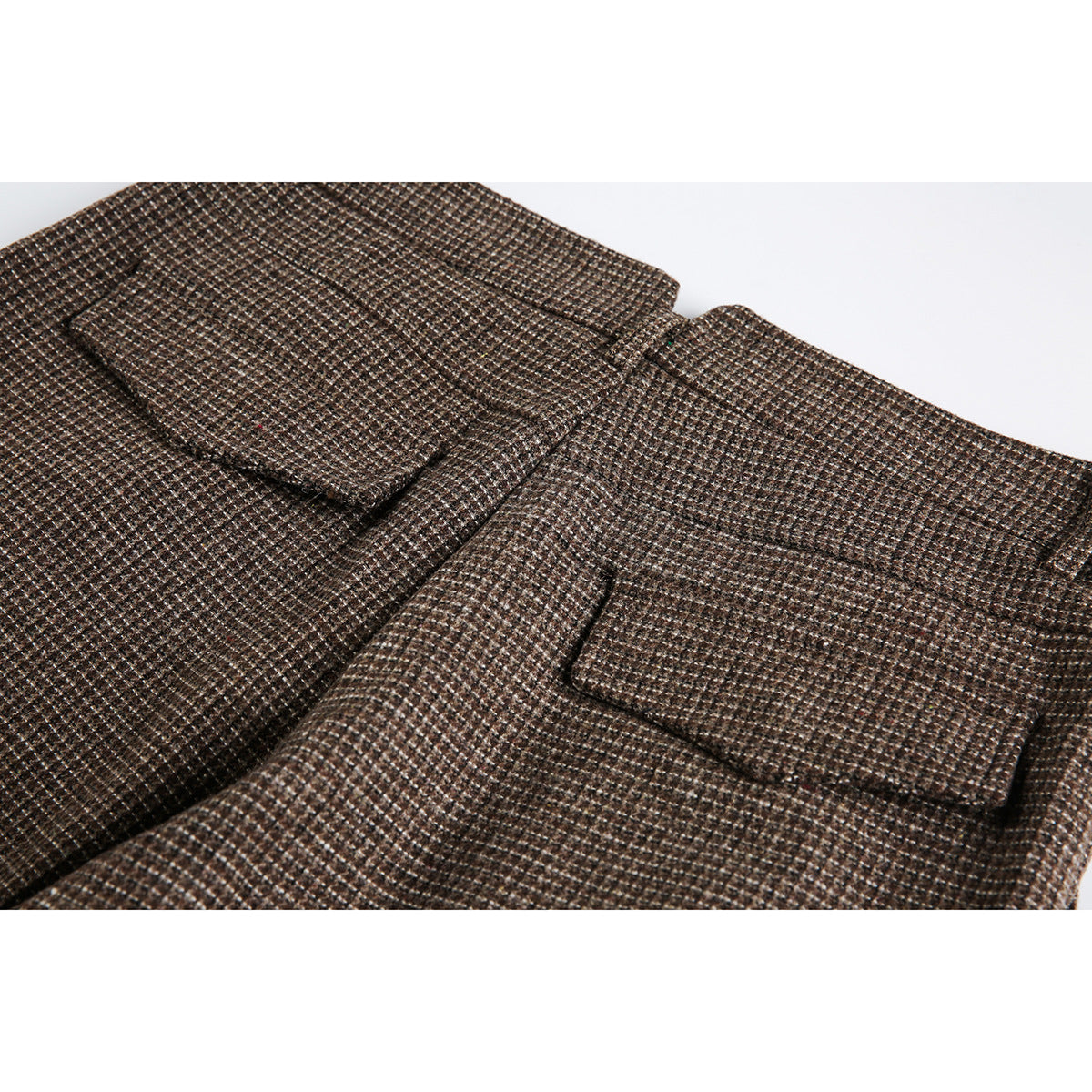 Close-up of brown small-check trousers showing two rectangular rear pockets.