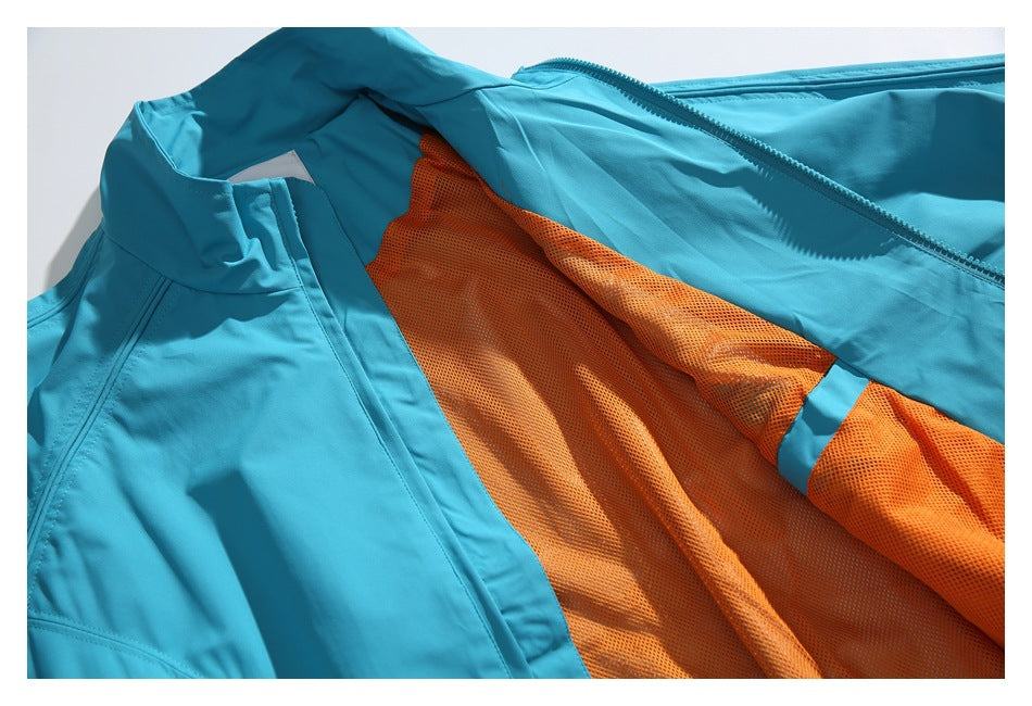 The turquoise jacket is open to show its bright orange mesh lining and raised collar.