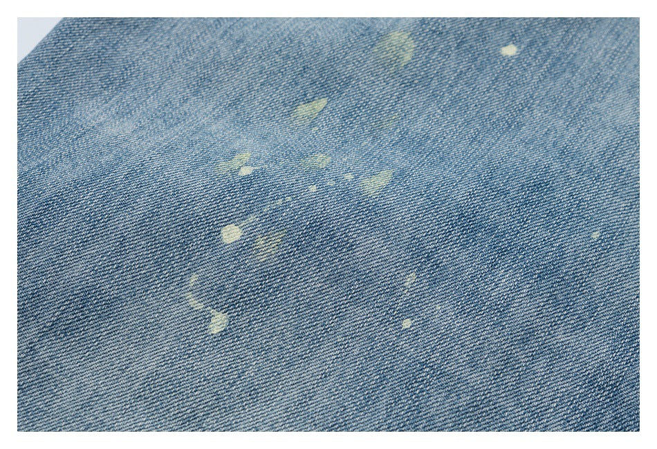 Close-up of blue denim with scattered pale distressed marks.
