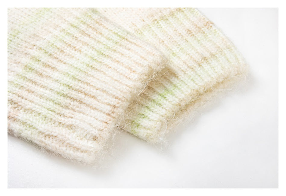 Close-up of a ribbed sleeve cuff and fuzzy knit texture with subtle pale green and pink streaks.
