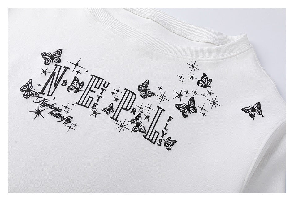 Close-up of a white sweatshirt chest with a black butterfly, starburst, and decorative lettering print.