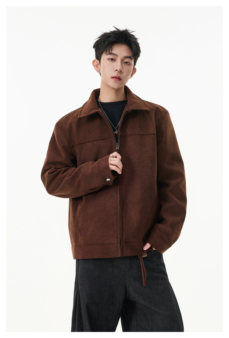 Model wearing brown suede-look zip jacket over a black tee and dark wide-leg jeans, partly unzipped