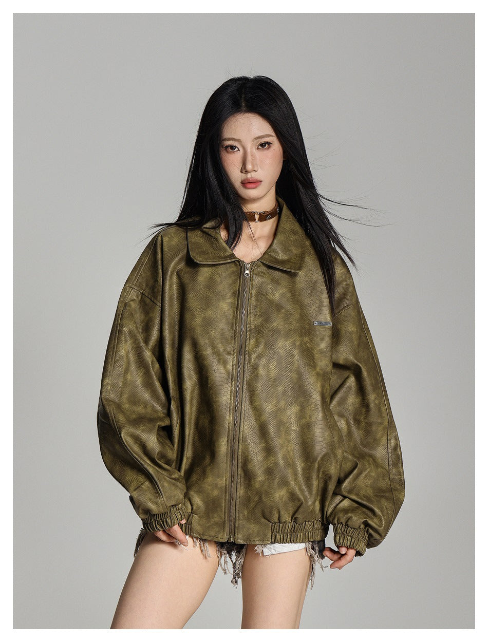 Model wearing an oversized olive textured zip jacket, shown from the front with its collar and zipper visible.