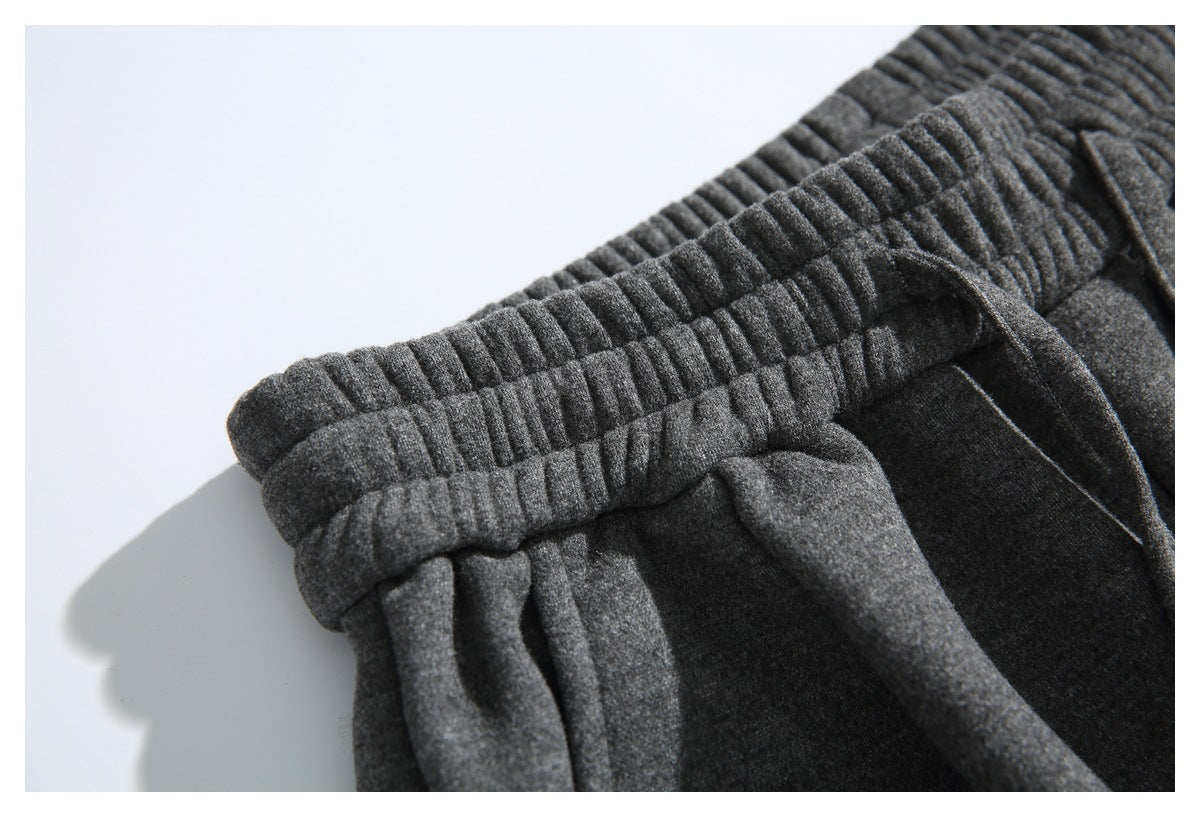 Close-up of the gathered elastic waistband and drawstring on dark gray pants.