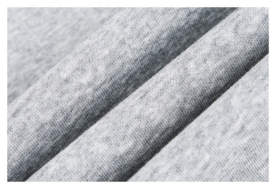 Macro view of light gray heather fabric draped in folds, showing its knit texture.
