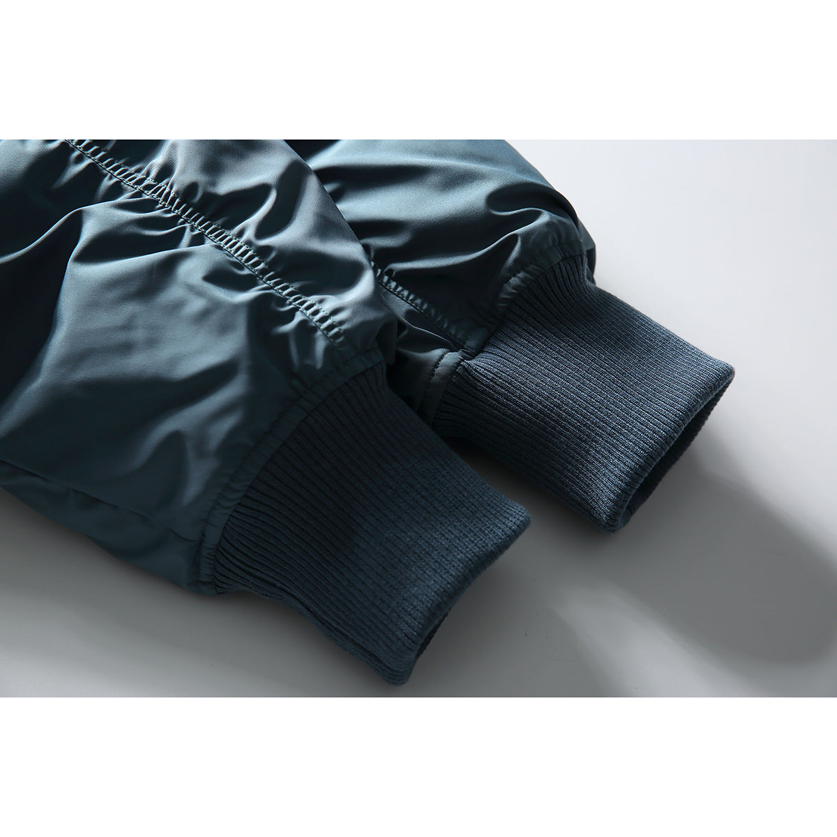 Close-up of the blue jacket's gathered sleeves and dark rib-knit cuffs.