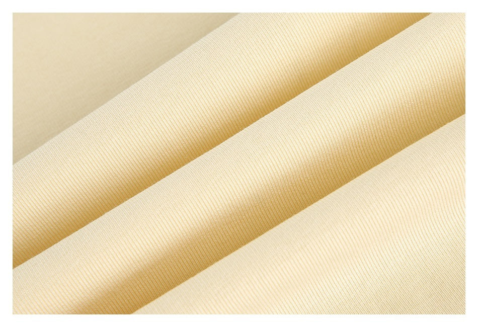 Close-up of pale cream fabric arranged in overlapping folds, showing its surface texture.